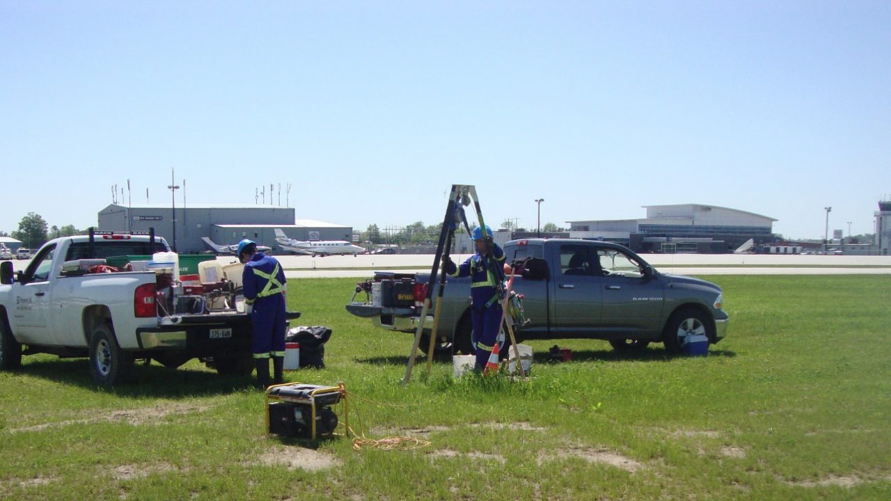 Grouting crew set up airside at an Ontario airport with the terminal and control tower behind