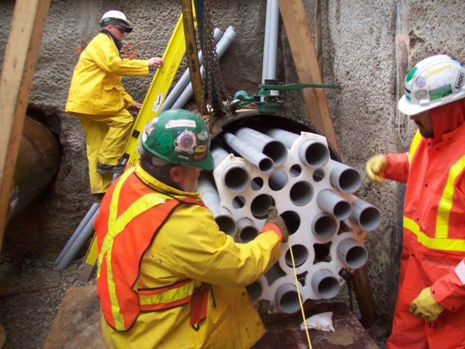 SG Services crew members in high-visibility safety gear preparing grout injection packers on site