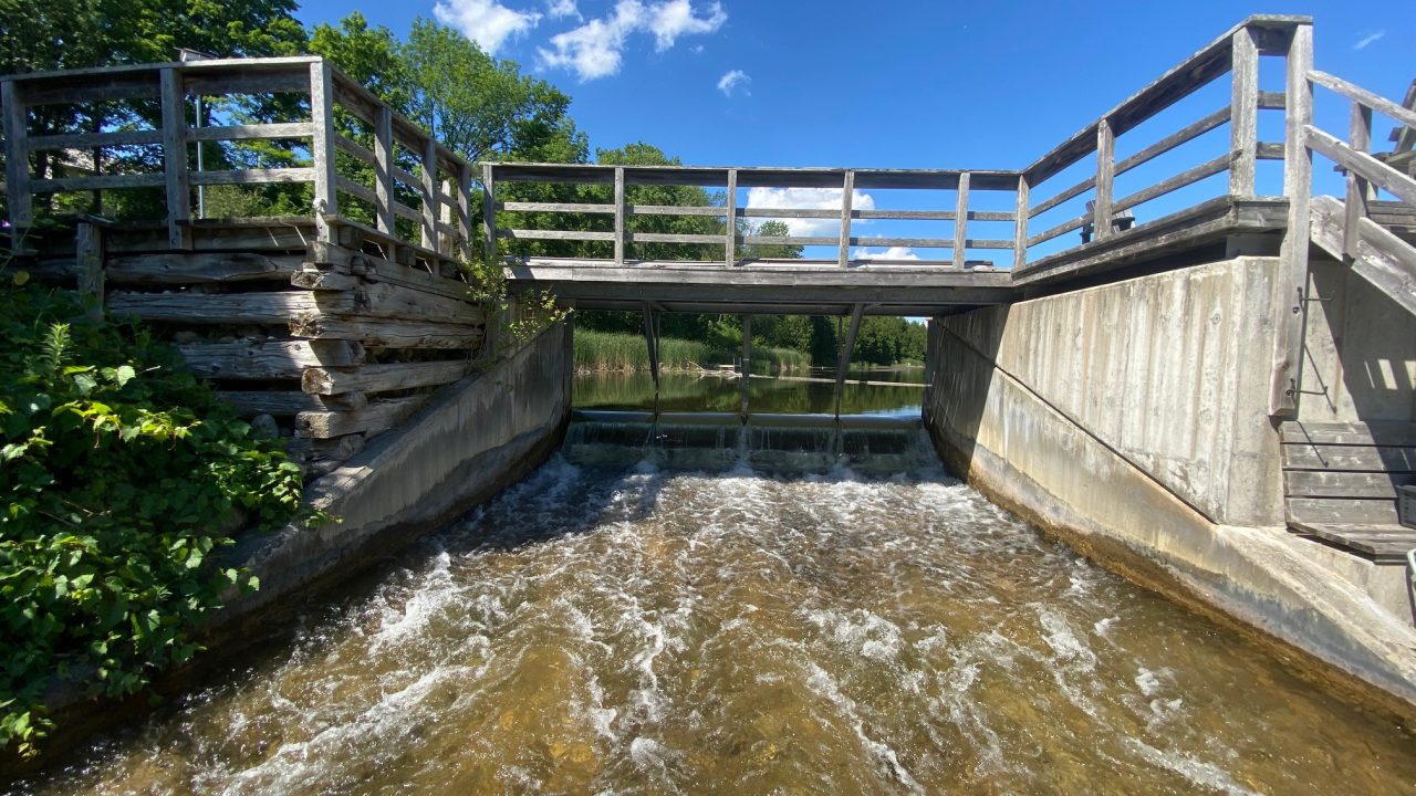 Water flowing through a concrete dam spillway — the hydraulic conditions SG Services seals against