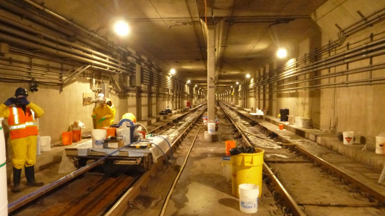 Crew injecting joints at track level inside the Calgary light rail transit tunnel