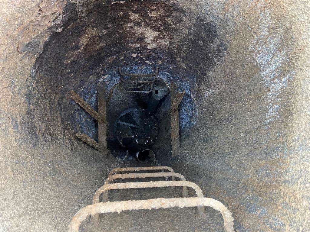 Corroded manhole ladder rungs and failed landing before replacement
